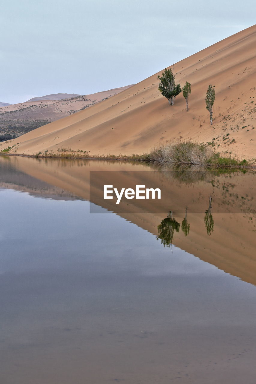 1037 lake badain east reflects a megadune of the badain jaran area-gobi desert. inner mongolia-china