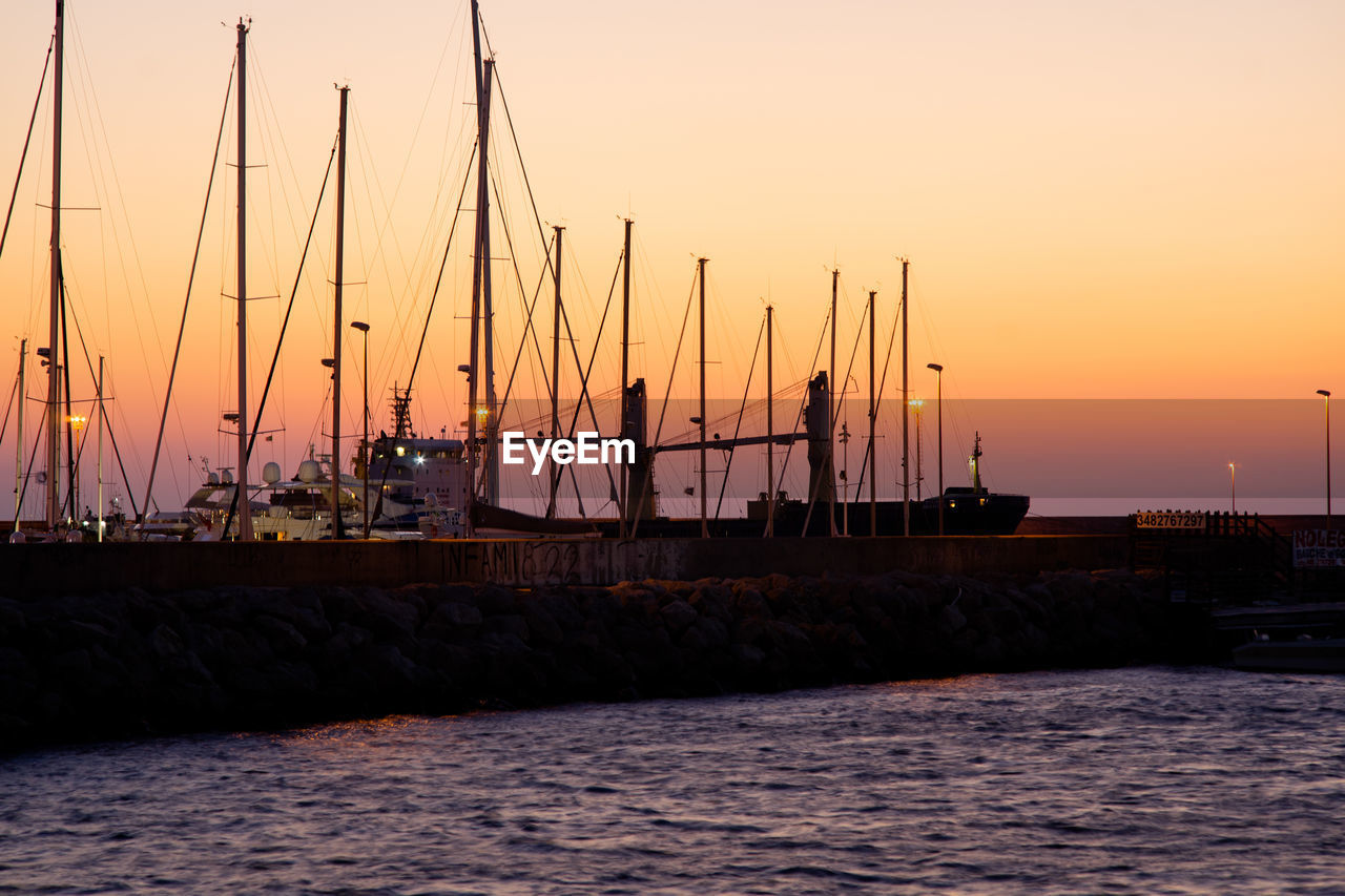 Silhouette sailboats on sea against sky during sunset