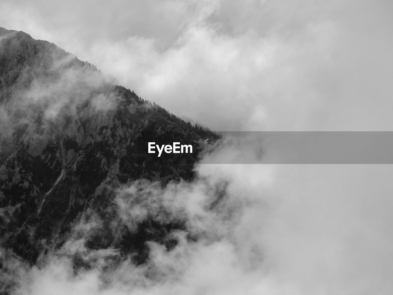 LOW ANGLE VIEW OF MOUNTAINS AGAINST CLOUDY SKY