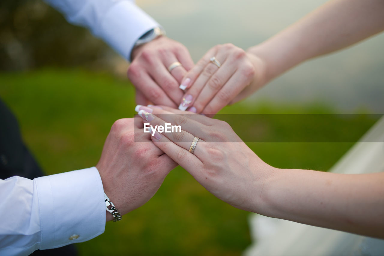 CLOSE-UP OF COUPLE HAND HOLDING HANDS OUTDOORS