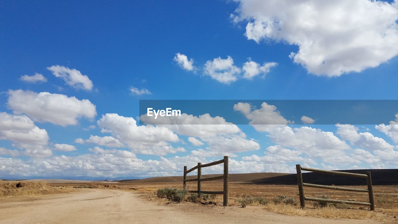 SCENIC VIEW OF DIRT ROAD AGAINST BLUE SKY