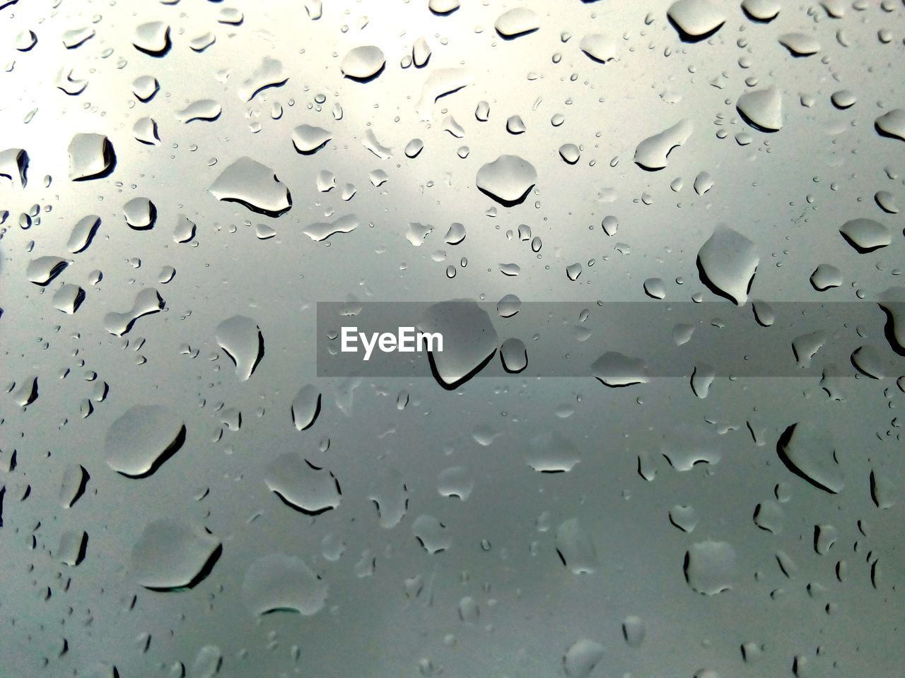 FULL FRAME SHOT OF WET GLASS WINDOW DURING MONSOON