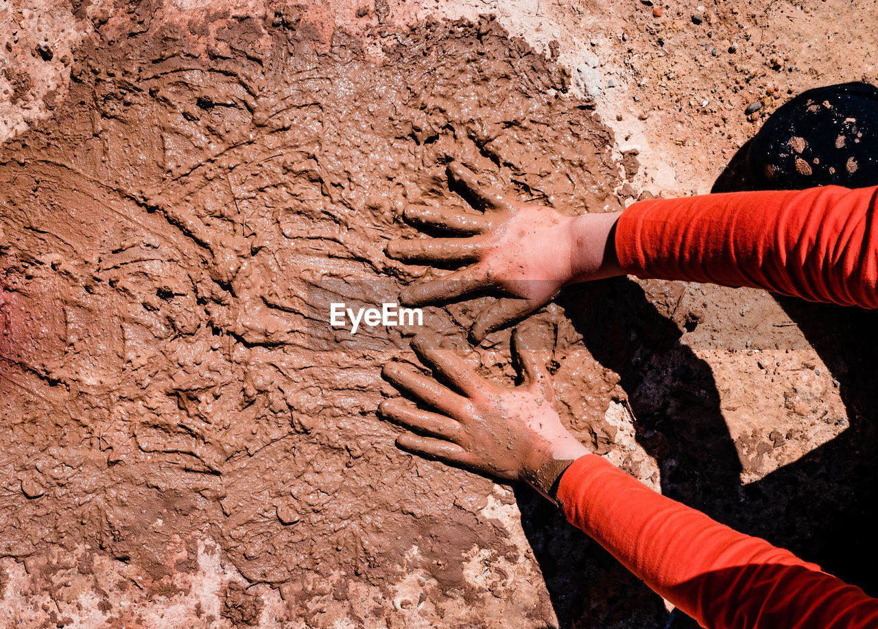 High angle view of human hand in mud