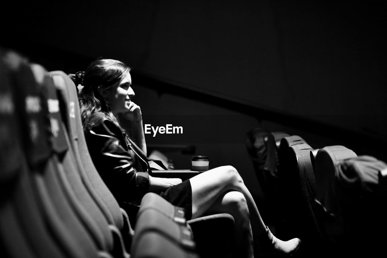Side view of woman watching a movie in a cinema