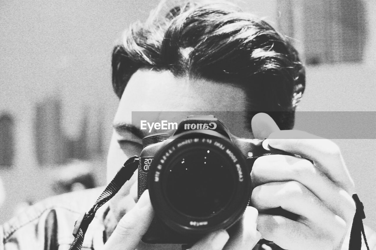 CLOSE-UP PORTRAIT OF YOUNG MAN PHOTOGRAPHING