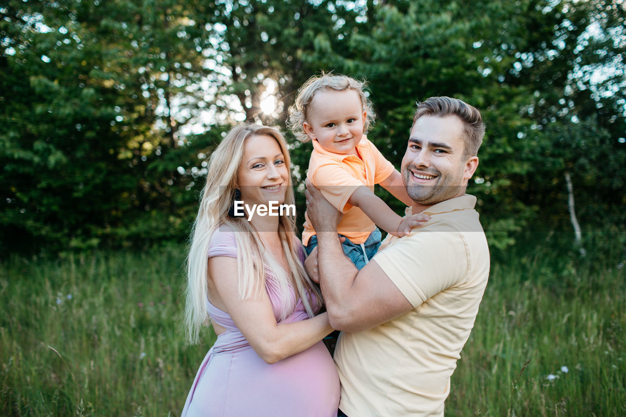 Portrait of happy family standing on field