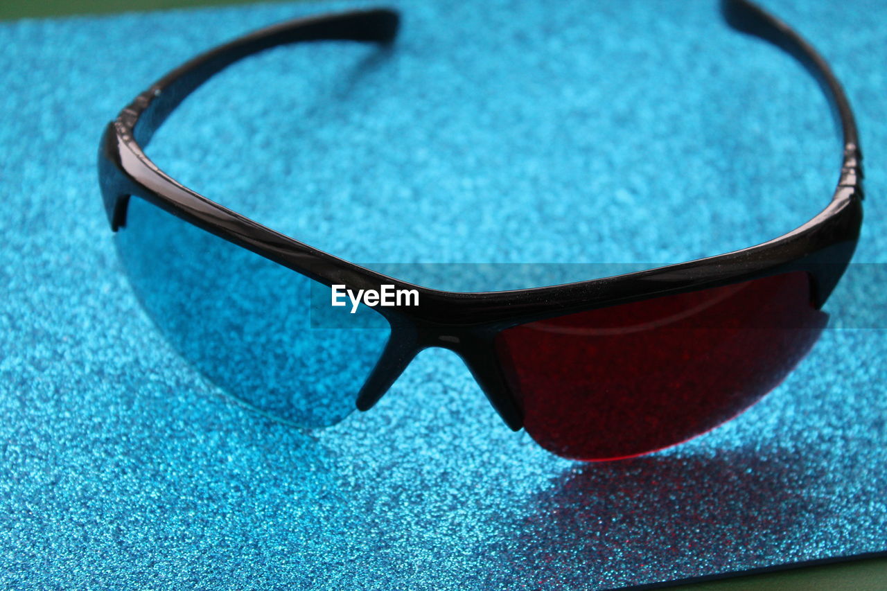 eyewear, vision care, glasses, fashion accessory, blue, sunglasses, close-up, no people, fashion, single object, indoors, focus on foreground, still life, azure, table, eyeglasses