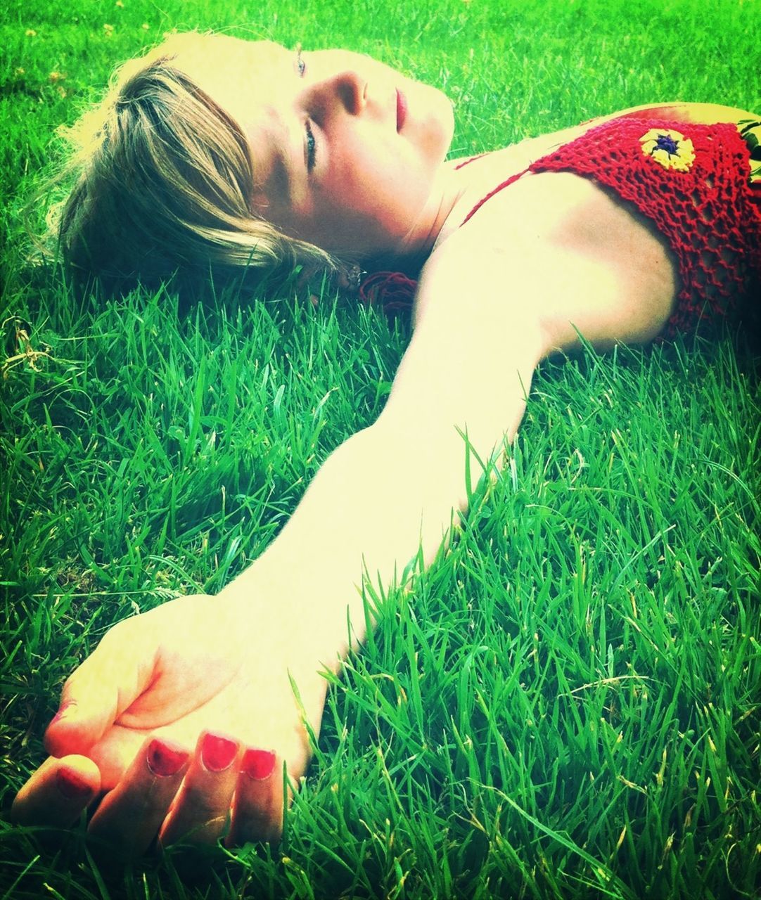 YOUNG WOMAN LYING DOWN ON GRASS