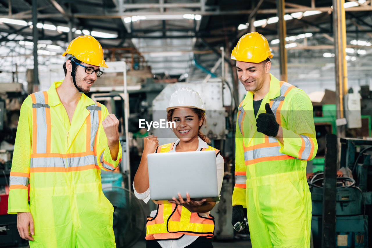 People working with laptop in factory