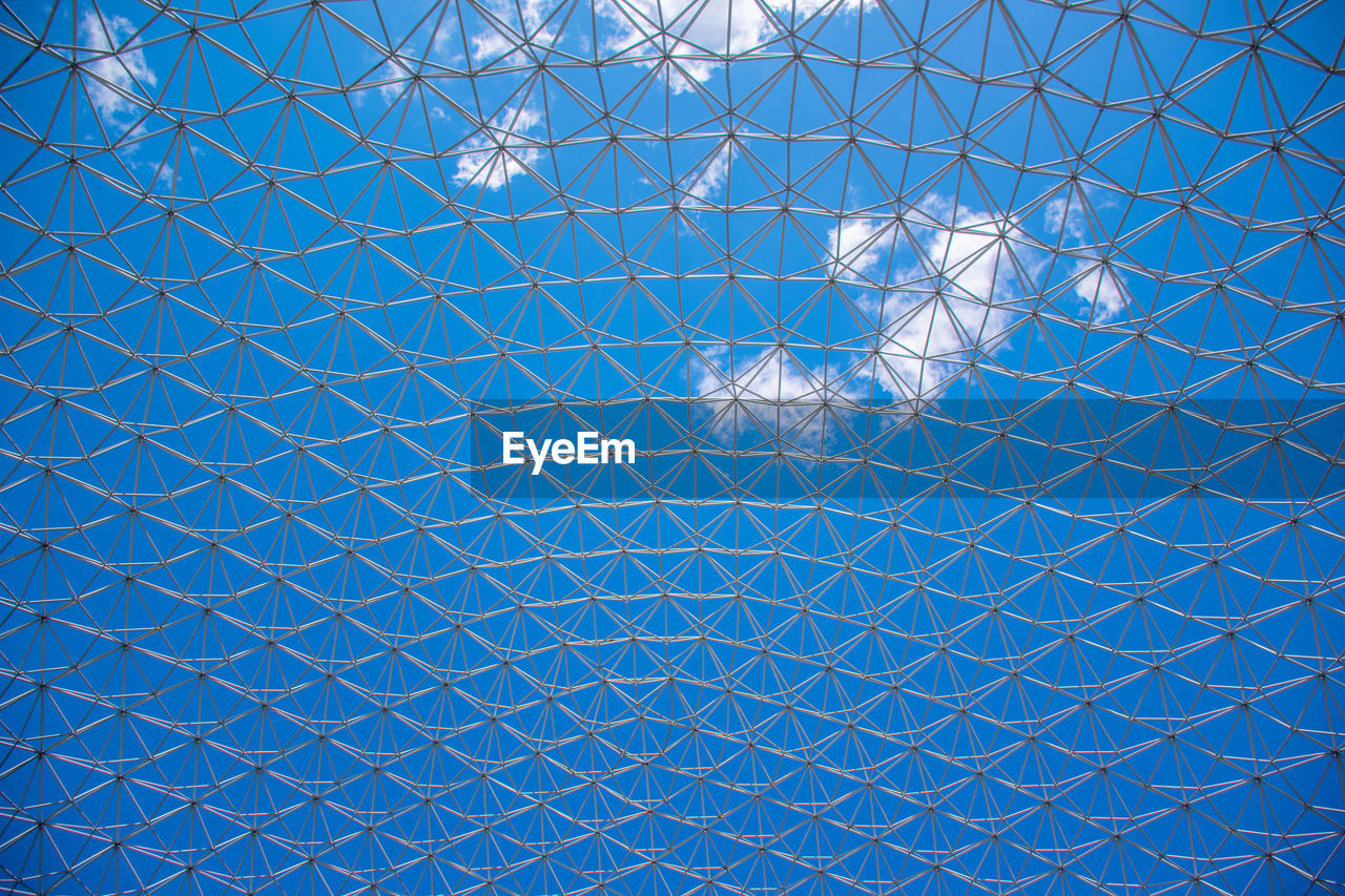 Full frame shot of illuminated glass ceiling against blue sky