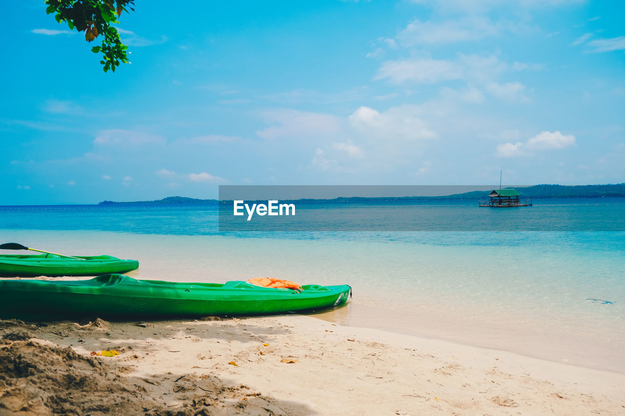 Boat moored on beach against sky