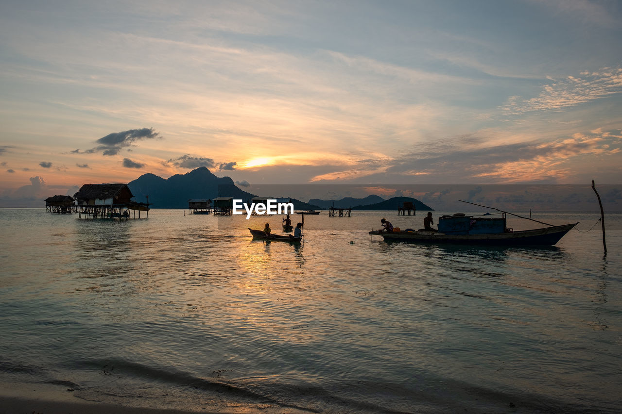 SILHOUETTE BOATS IN SEA AGAINST SKY