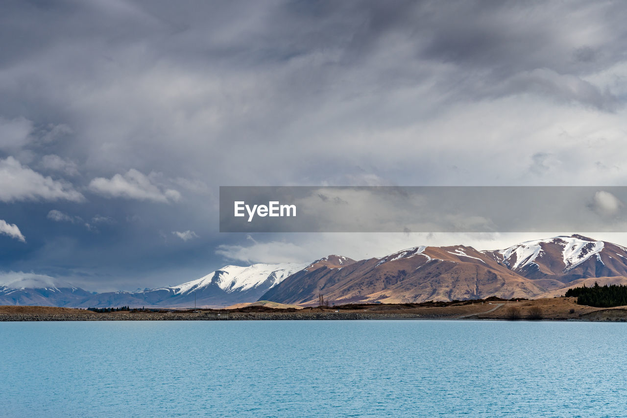A scenic landscape of new zealand southern alps and lake pukaki with blue sky and clouds.