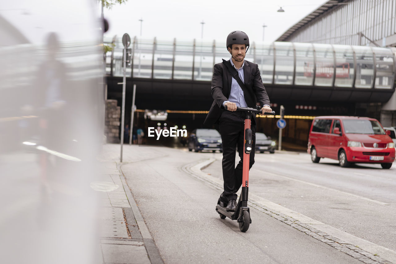 Businessman riding e-scooter in the city