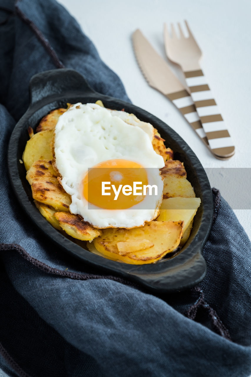 Close-up of fried egg in bowl on napkin over table