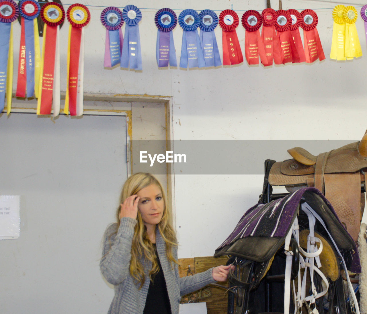 Portrait of woman standing below colorful hanging badges