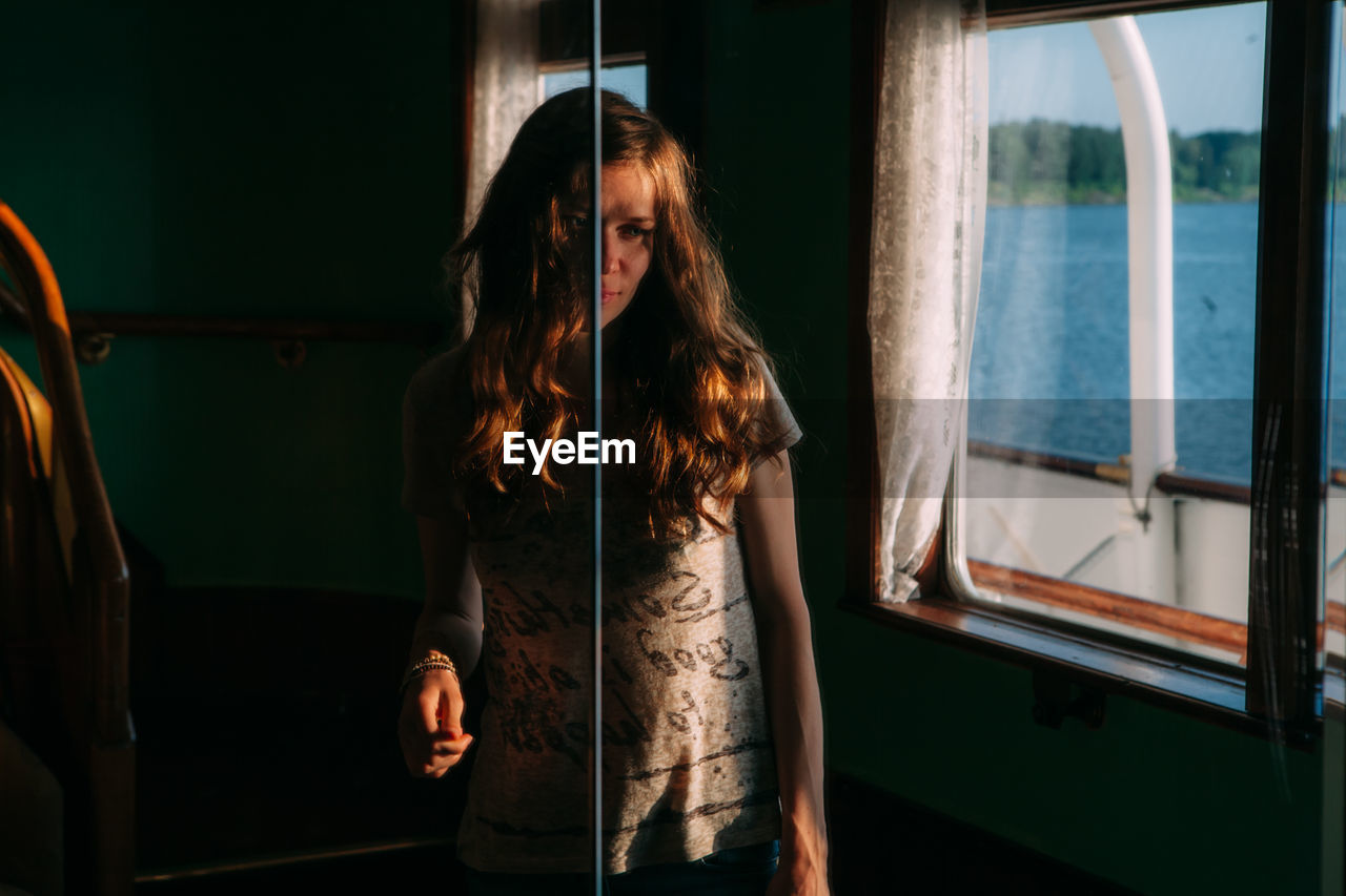 Woman standing in ferry by window