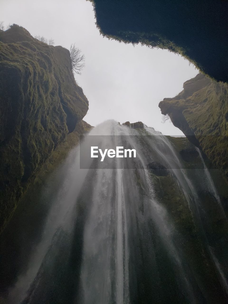 Upward view of waterfall and rocky landscape