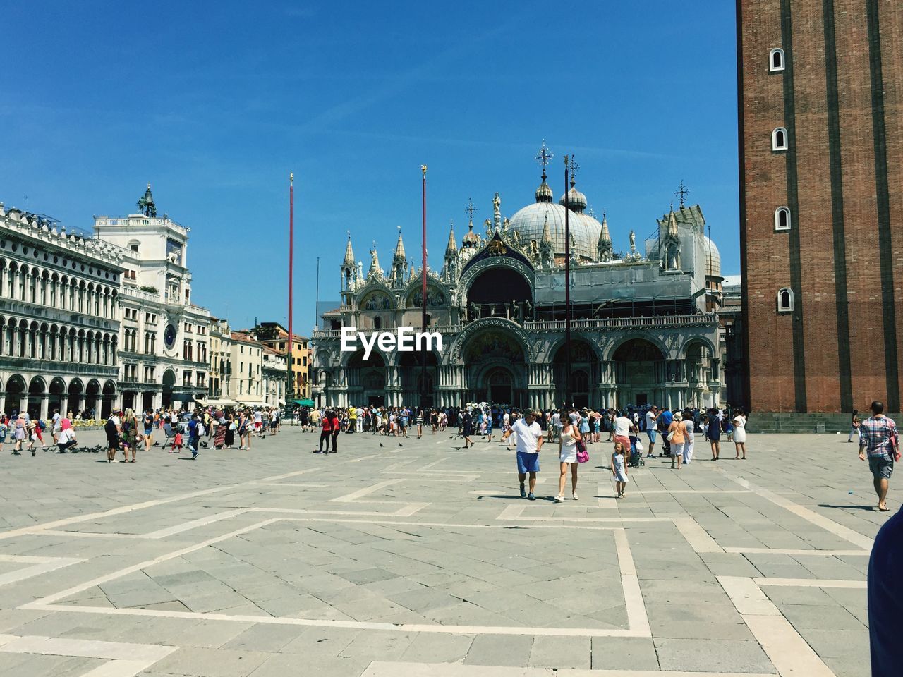 TOURISTS AT TOWN SQUARE AGAINST SKY