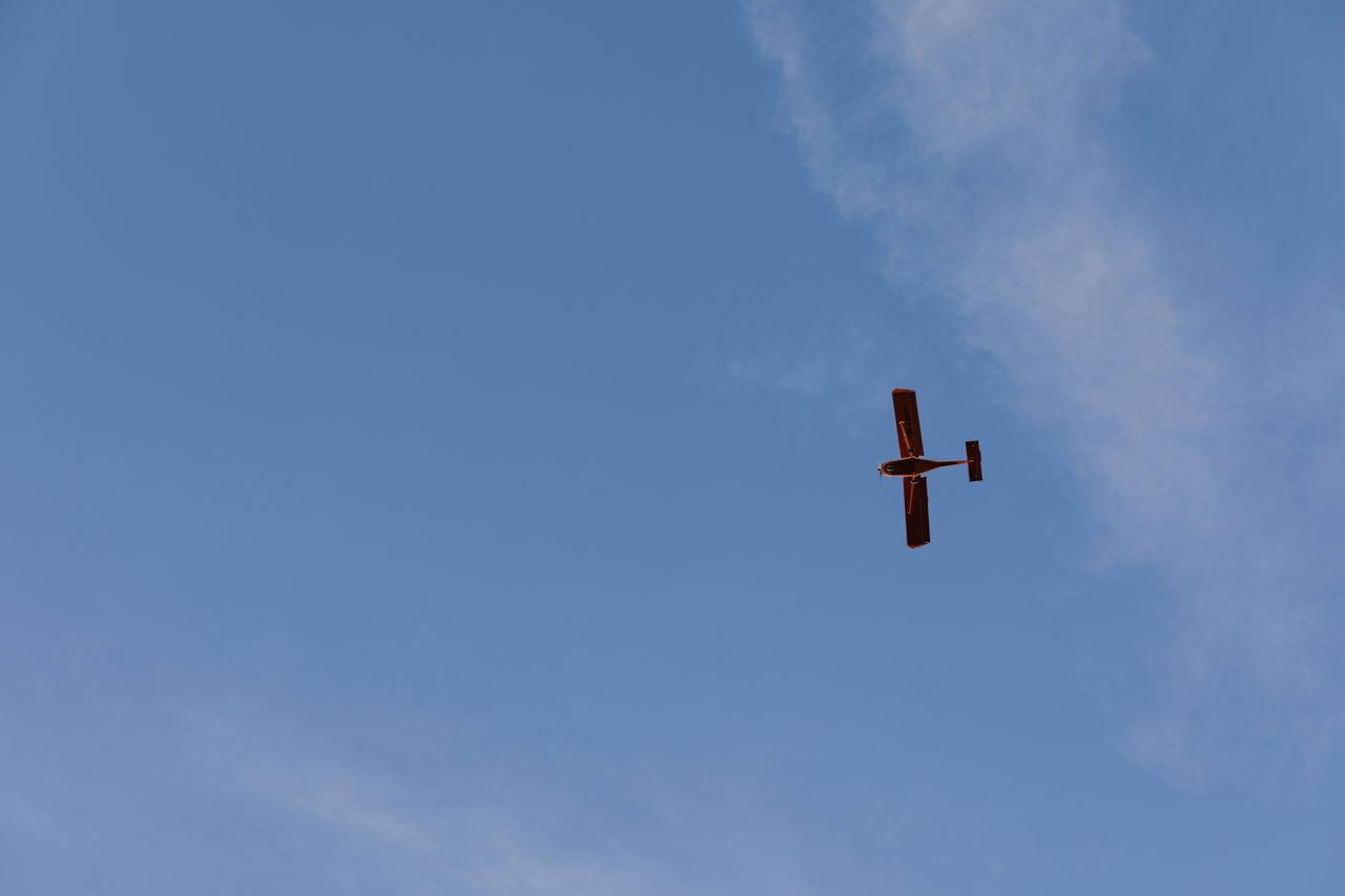 Low angle view of airplane flying against clear blue sky