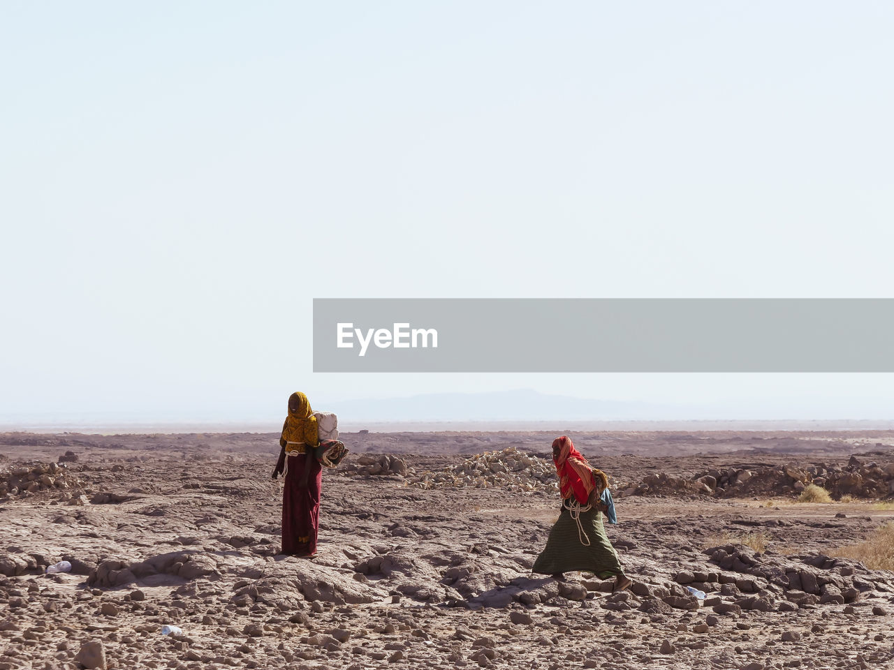 PEOPLE ON DESERT AGAINST CLEAR SKY