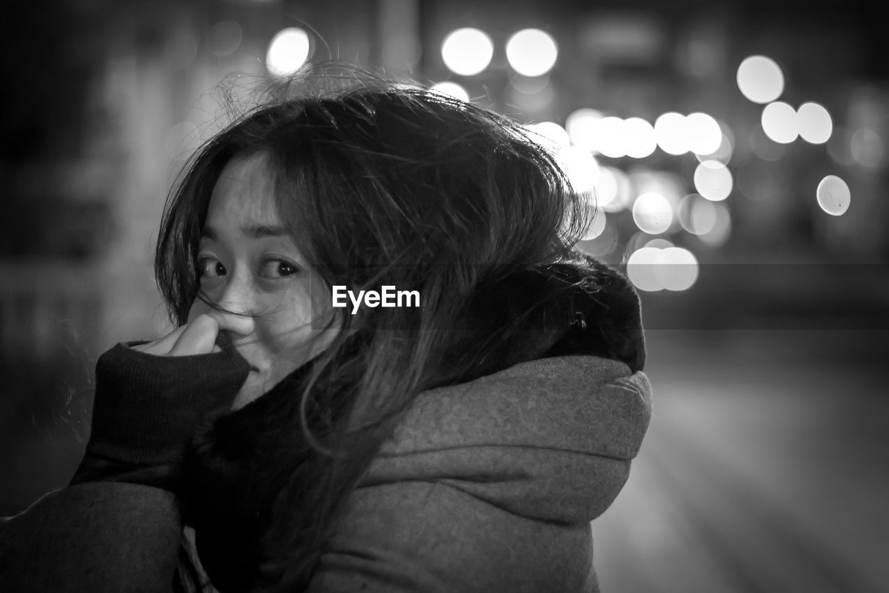 YOUNG WOMAN LOOKING AWAY AT NIGHT