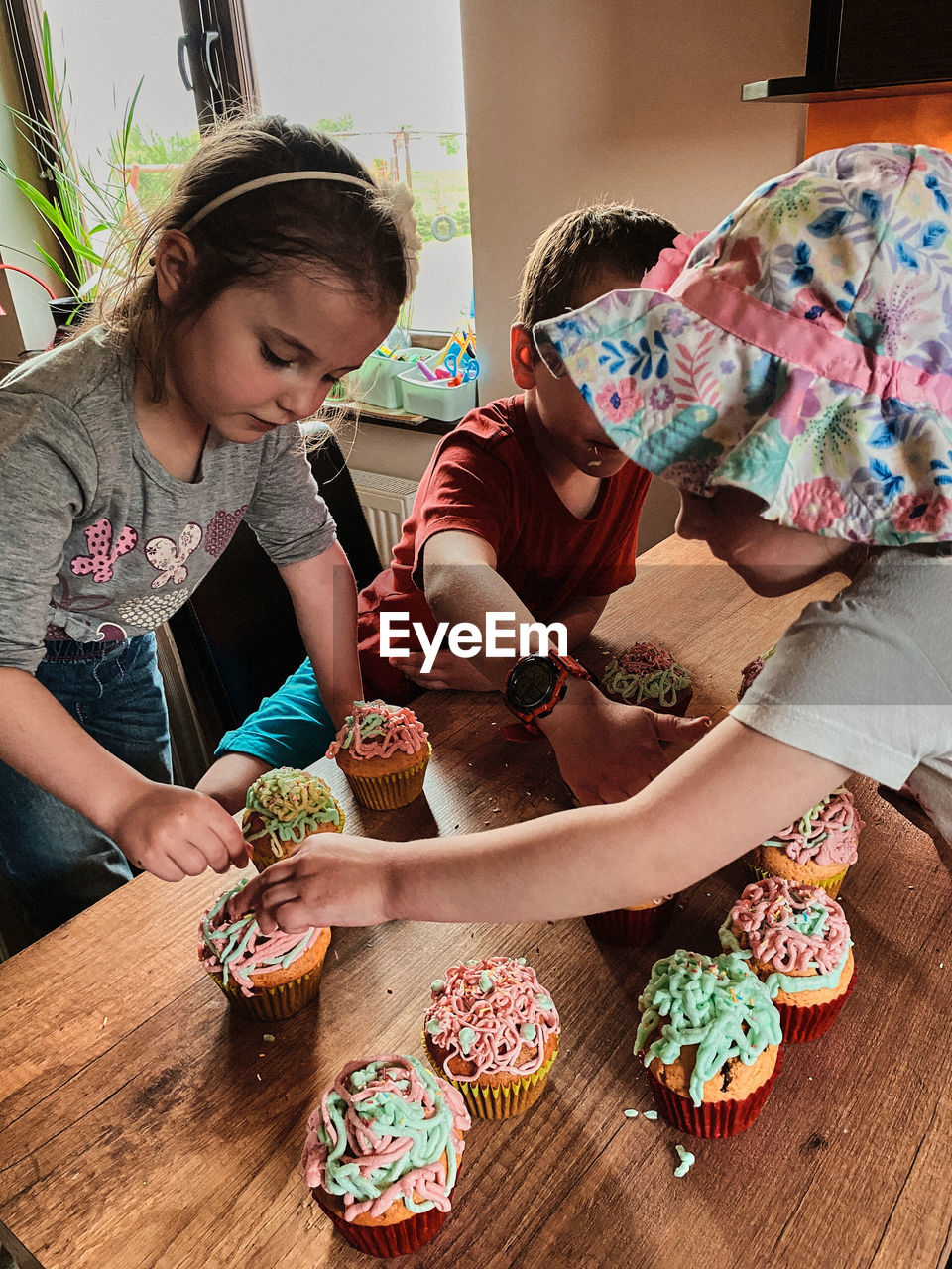 Group of children baking cupcakes, preparing ingredients, topping, sprinkles for decorating