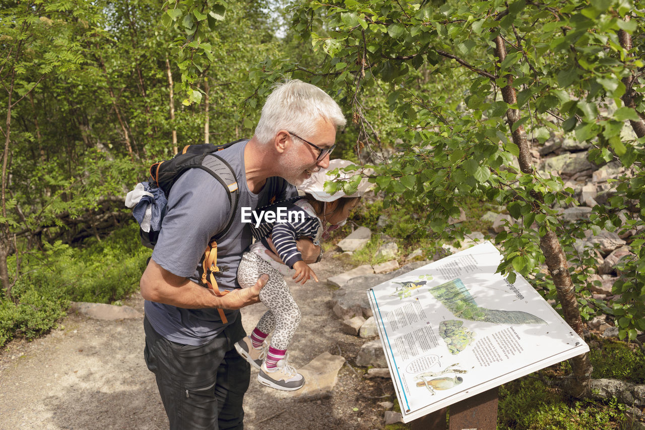 Father with toddler girl looking at map