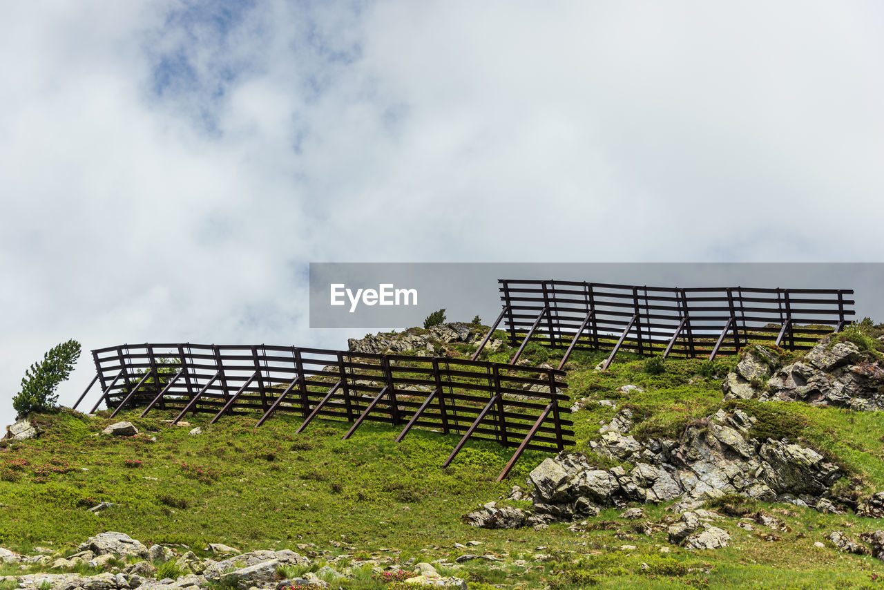 Avalanche protection fences in the alpine mountains. steel snow bridges, sliding snow stands, summer