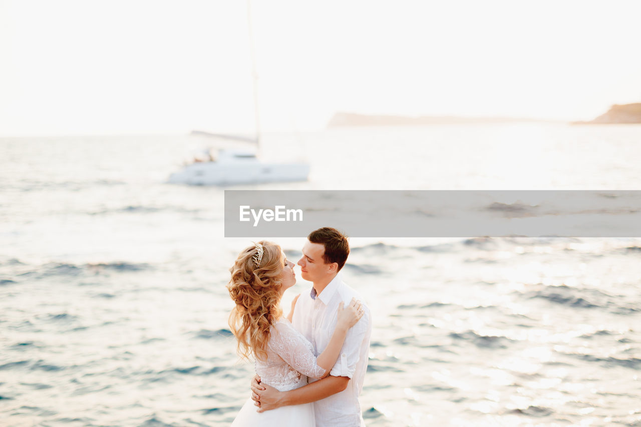 Side view of couple standing at sea shore