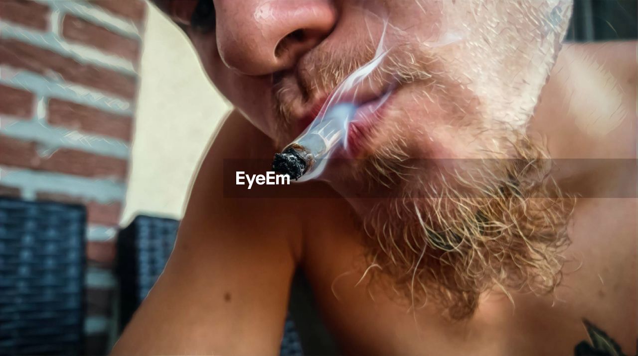 Close-up of man smoking marijuana joint