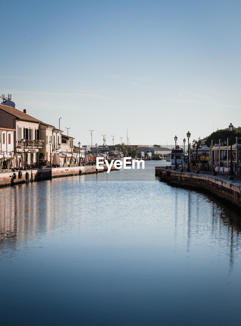 City buildings by river against clear sky