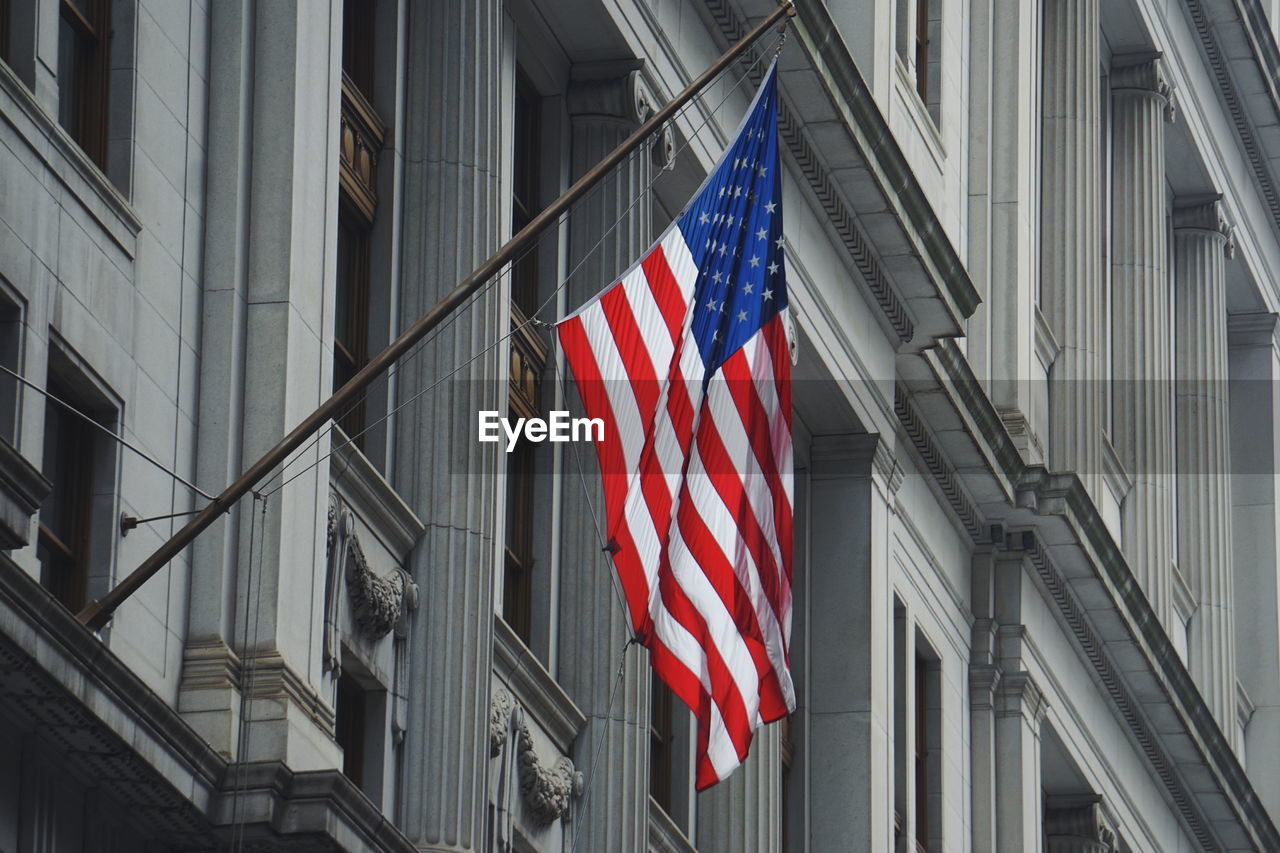 American flag hanging on building in city