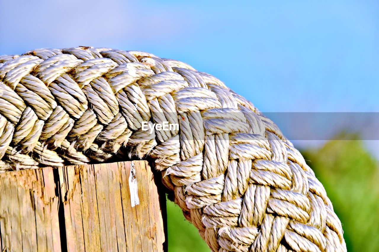 CLOSE-UP OF ROPE TIED WOODEN POST