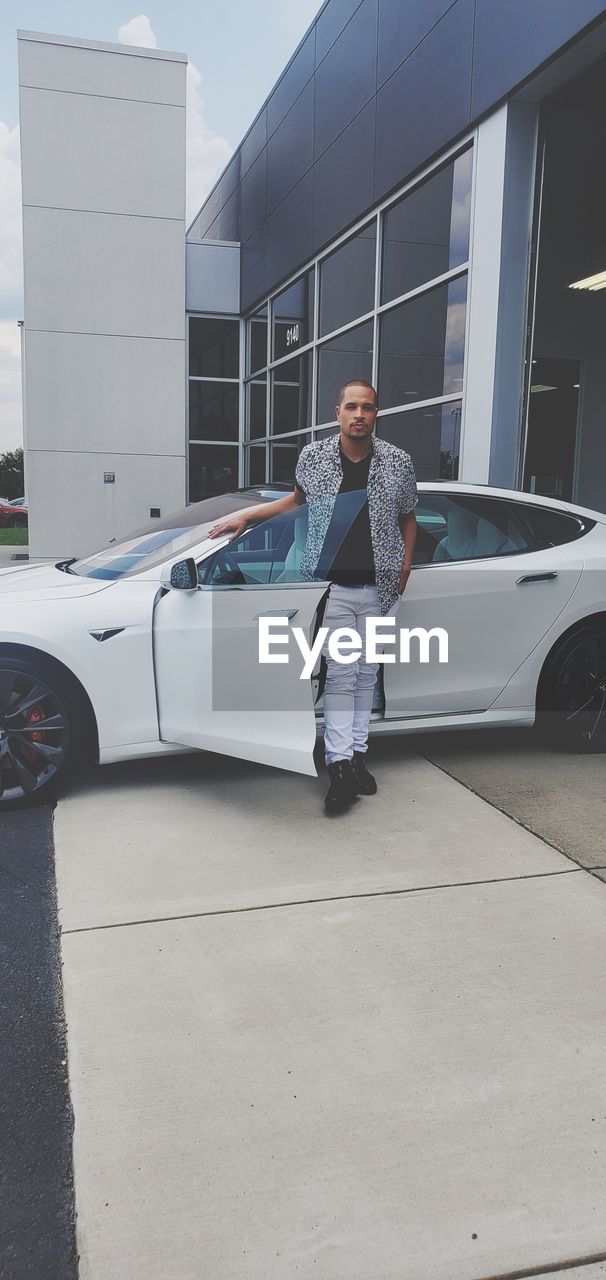 Full length of man standing by car