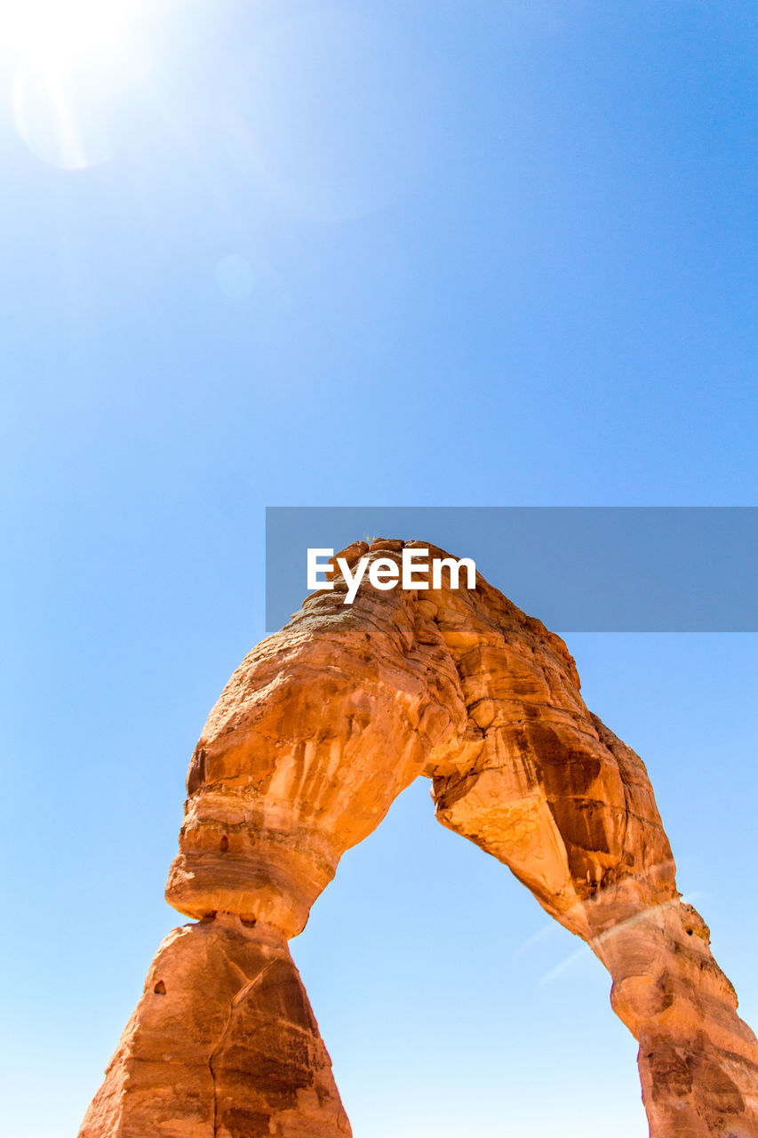 View of natural arch against clear sky during sunny day