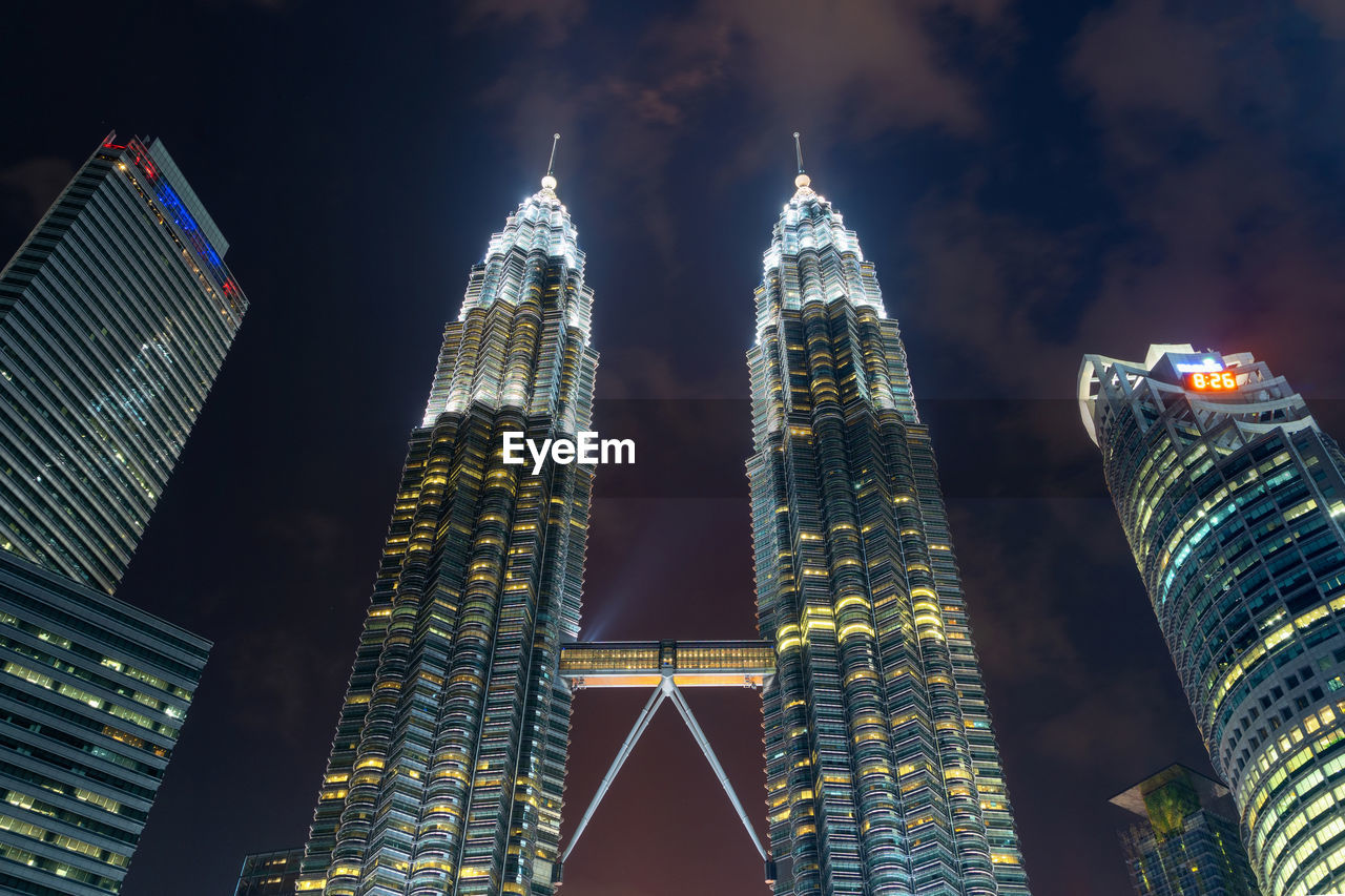 Low angle view of illuminated buildings against sky at night