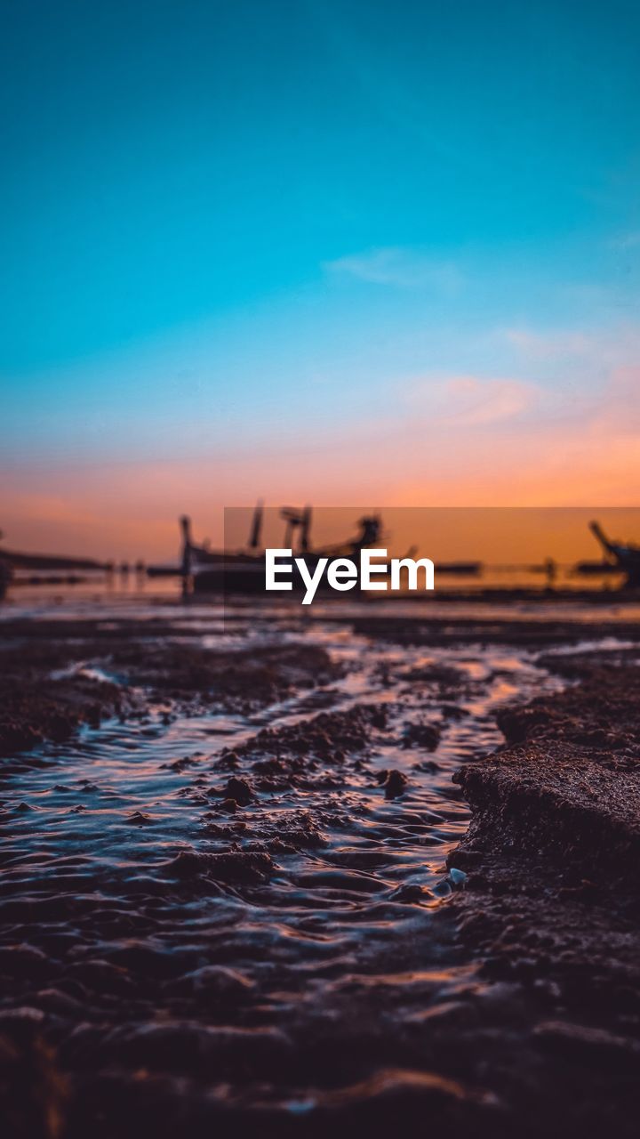 Surface level shot of sea against dramatic sky during sunset