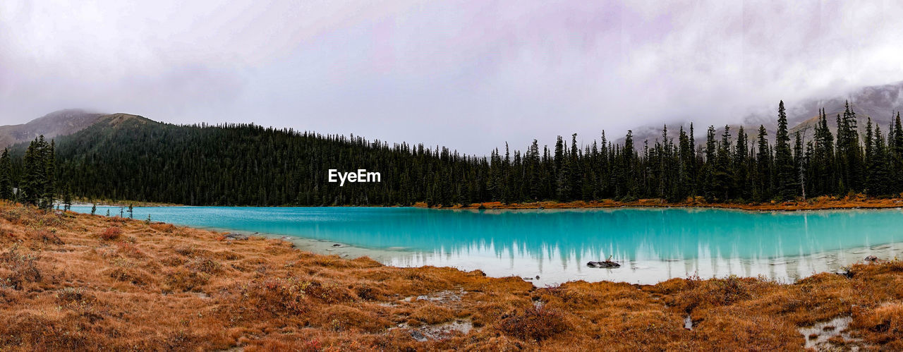 Scenic view of lake by mountains against sky