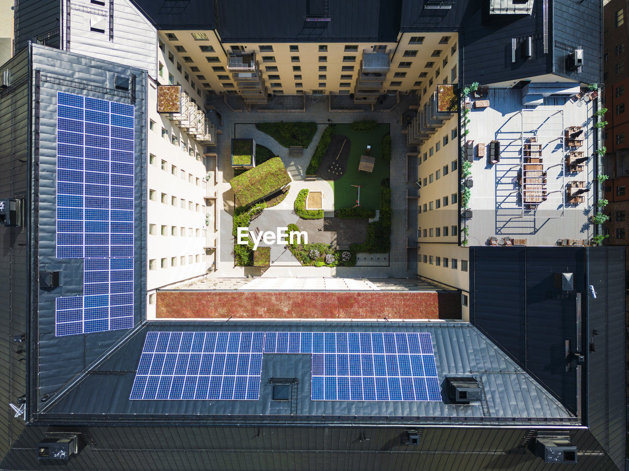 Aerial vie of courtyard surrounded by block of flats, solar panels on roof