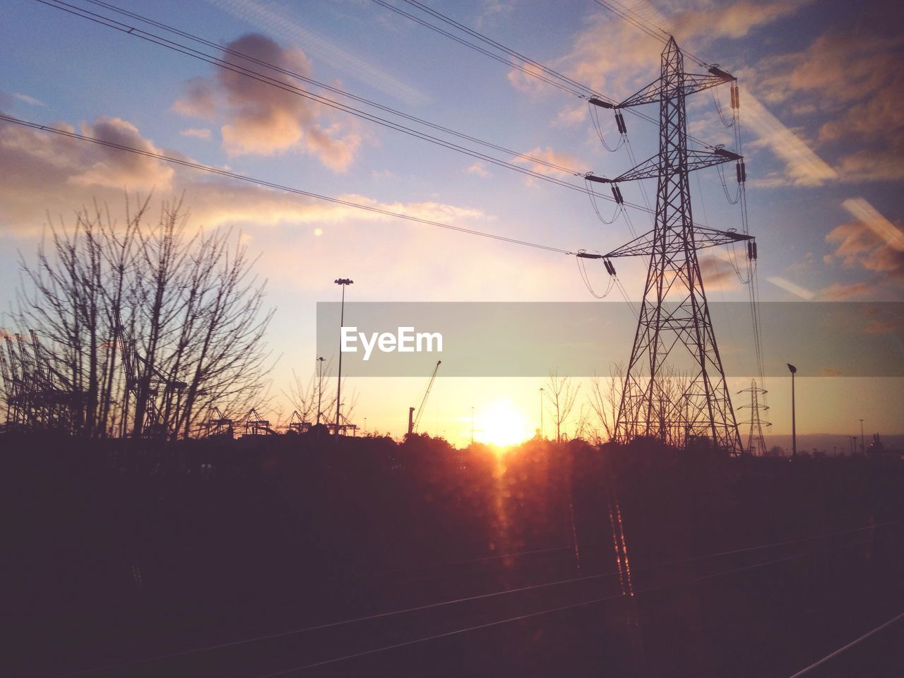 SILHOUETTE OF ELECTRICITY PYLONS AT SUNSET