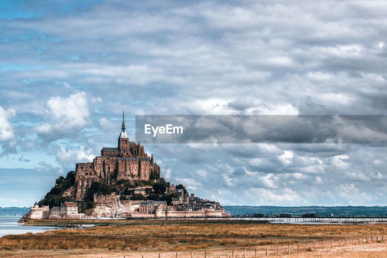Scenic view of mont saint-michel against cloudy sky