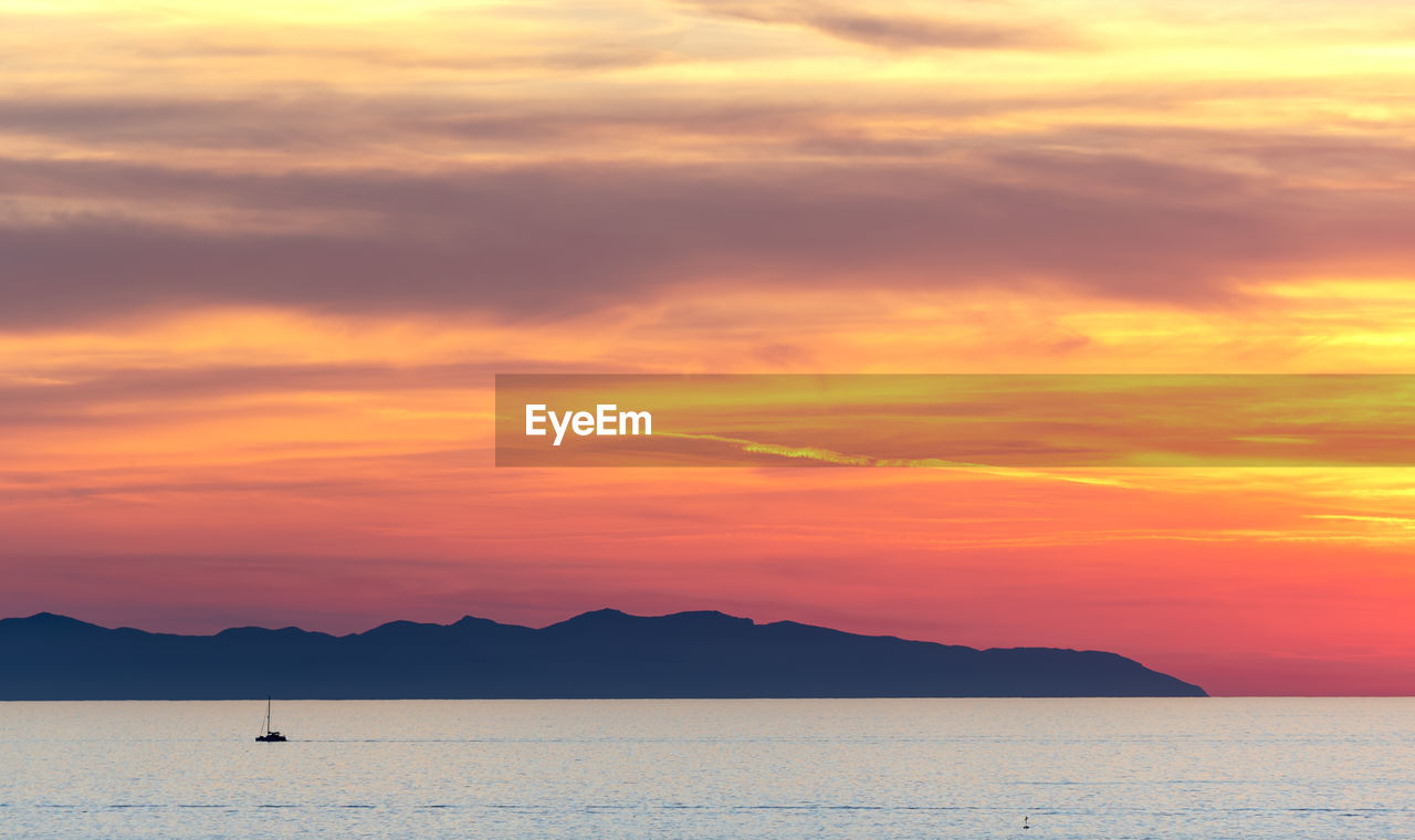 Scenic view of sea against orange sky