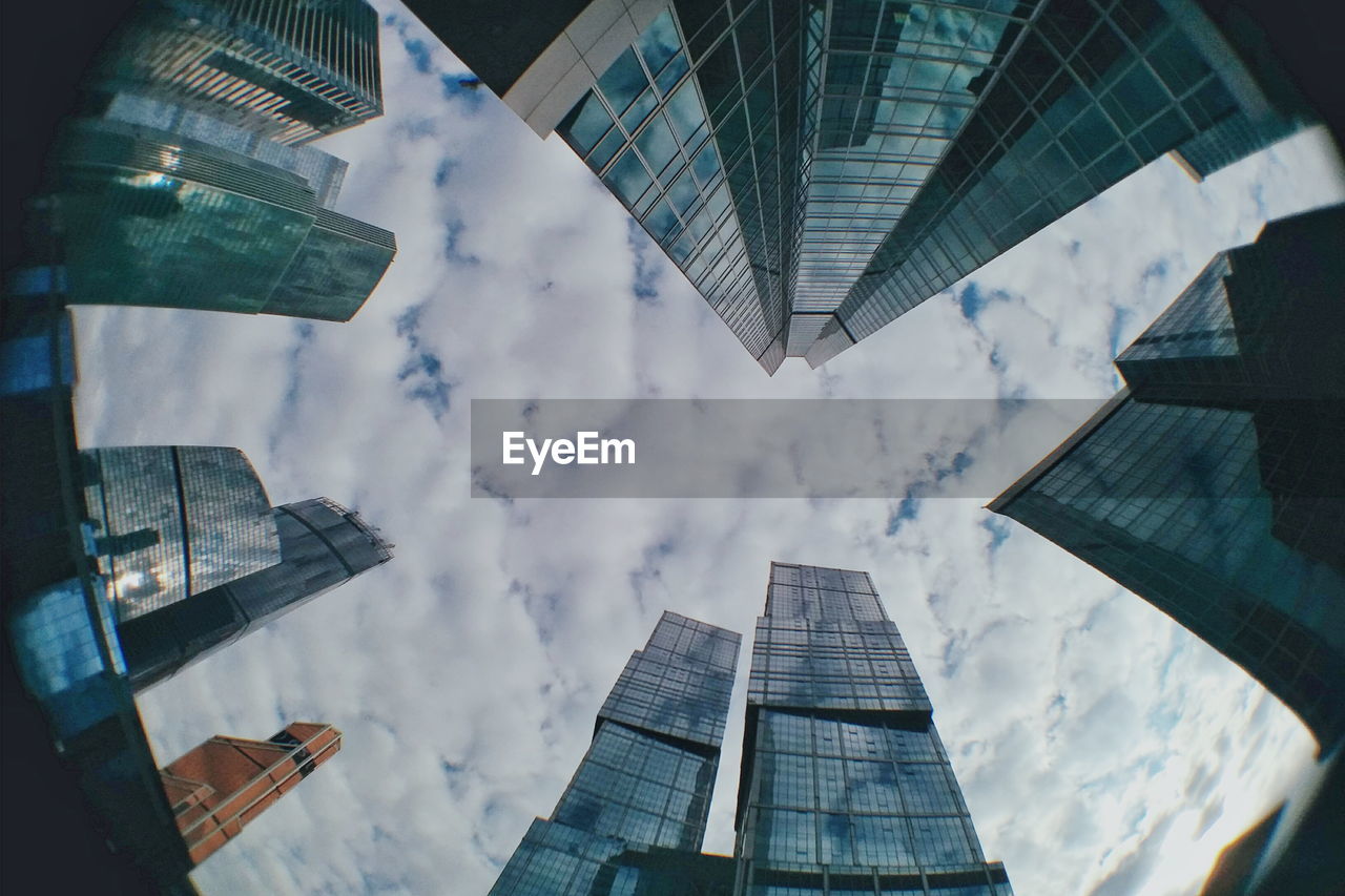 Low angle view of modern building against cloudy sky