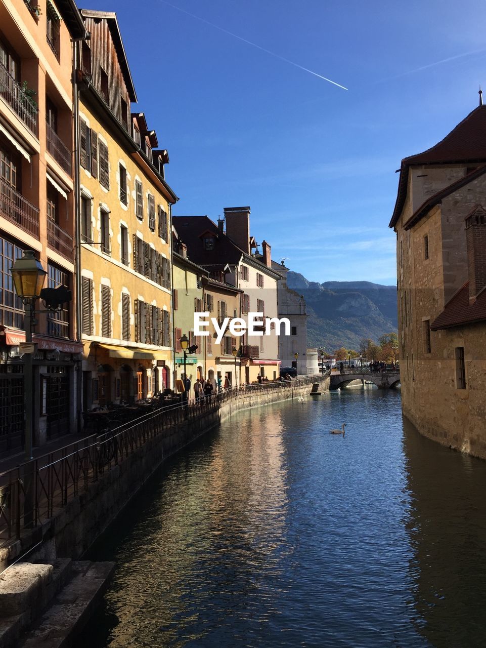 Canal amidst buildings in town against sky