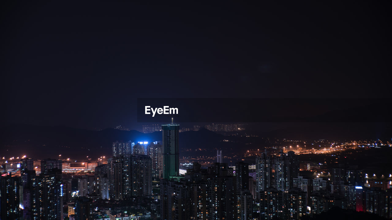 ILLUMINATED MODERN BUILDINGS IN CITY AT NIGHT