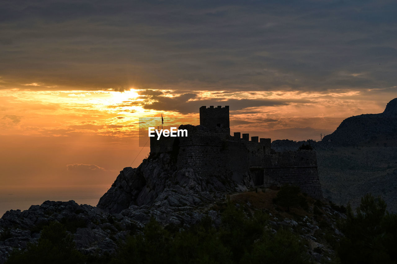 Buildings against cloudy sky during sunset