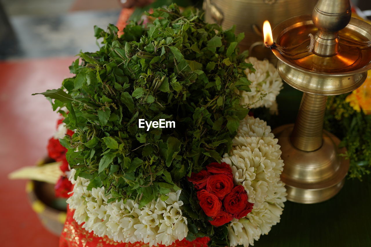 floristry, flower, plant, nature, floral design, candle, flowering plant, centrepiece, no people, religion, indoors, close-up, food and drink, freshness, red, food, beauty in nature, belief, decoration, focus on foreground