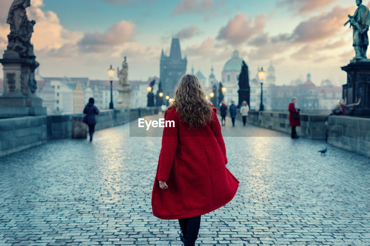 REAR VIEW OF WOMEN WALKING ON HISTORICAL BUILDING