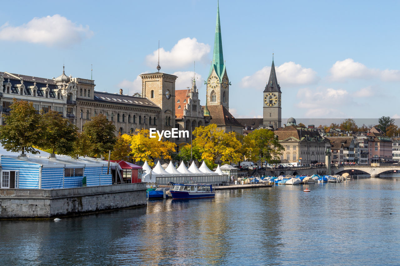 View at the waterfront of limmat river in zurich  with ships, churchs and other buildings